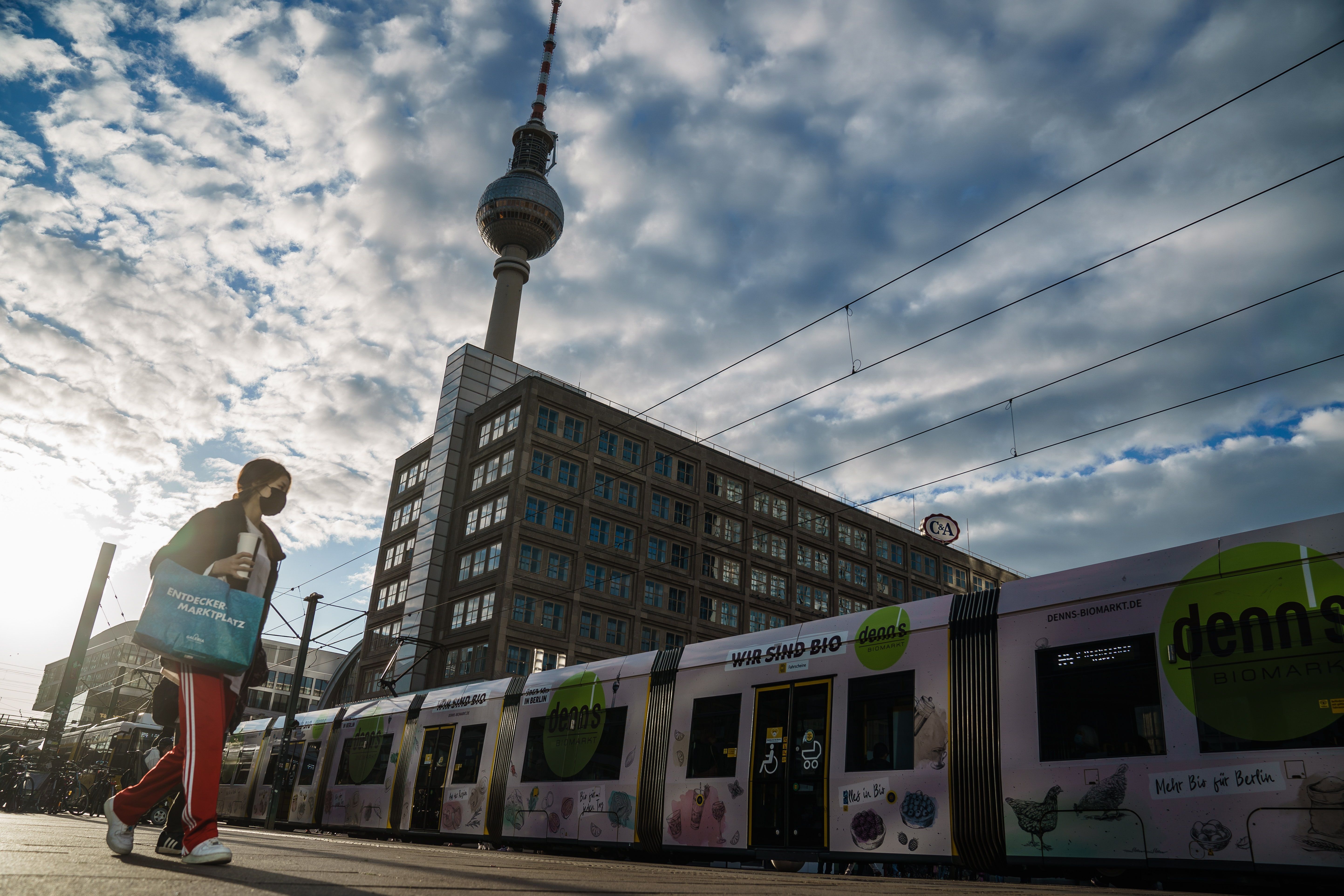 Una mujer con mascarilla camina por la plaza Alexanderplatz frente a una torre de televisión en Berlín. EFE /CLEMENS BILAN
