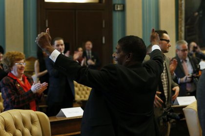 Un elector celebra después de confirmar su voto (Fotógrafo: Jeff Kowalsky/Bloomberg)