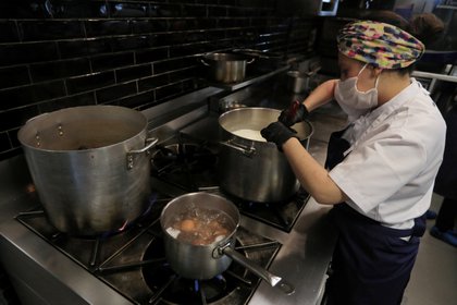 A chef from El Chato restaurant wearing a face mask cooks food, amid the coronavirus disease (COVID-19) outbreak in Bogota, Colombia June 2, 2020. Picture taken June 2, 2020. REUTERS/Luisa Gonzalez