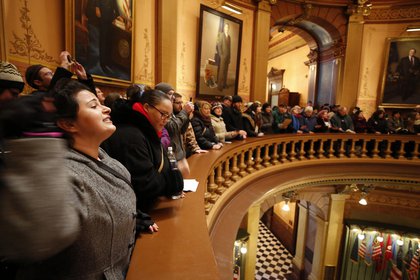 Un grupo de manifestantes se reúne en la rotonda del edificio del capitolio estatal en Lansing para pedir a los electores que no voten por Trump (Fotógrafo: Jeff Kowalsky/Bloomberg)