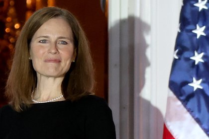 U.S. President Donald Trump casts a shadow behind Judge Amy Coney Barrett after she was sworn in as an associate justice of the U.S. Supreme Court on the South Lawn of the White House in Washington, U.S. October 26, 2020.  REUTERS/Jonathan Ernst