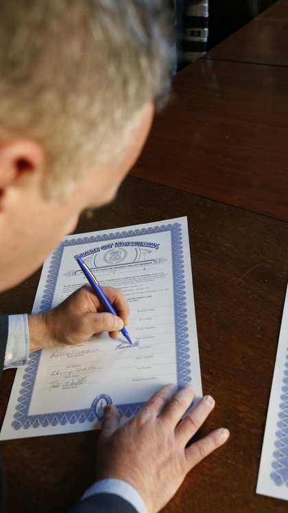 Un elector firma un acta confirmando su voto por Donald Trump en Michigan (Fotógrafo: Jeff Kowalsky/Bloomberg)