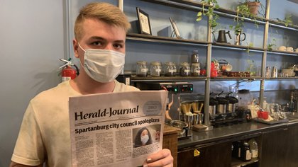 Harrison MacGuiness, de 21 años, muestra la portada del "Spartanburg Times" con la histórica decisión de la ciudad del sur estadounidense / SEBASTIÁN FEST