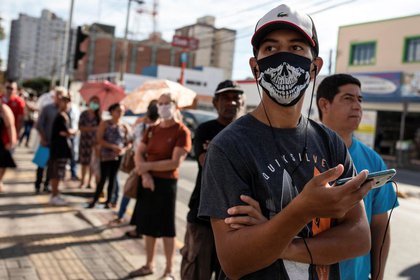 Un grupo de personas hacen fila en Sao Paulo para cobrar una ayuda del gobierno de Brasil a los más necesitados en medio de la pandemia de coronavirus. (REUTERS/Roosevelt Cassio)