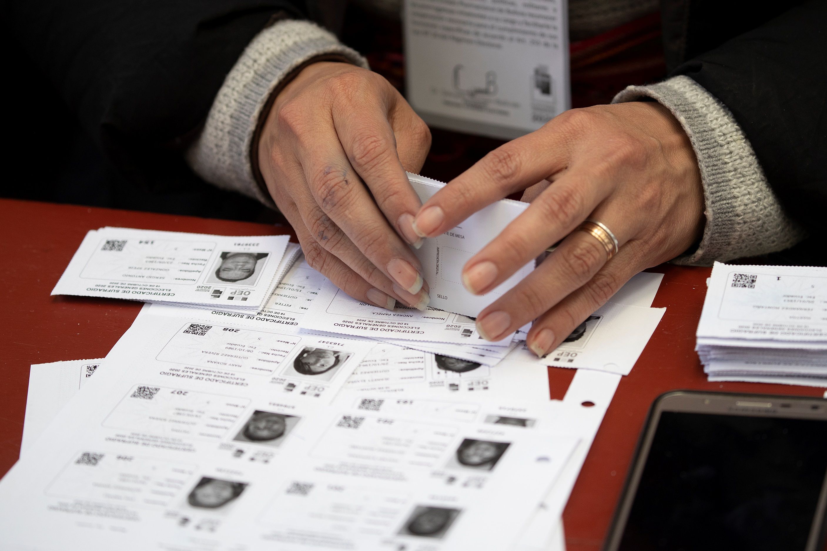 Detalle de un inspector con varios certificados de votación, hoy en una escuela de La Paz (Bolivia). EFE/ Joédson Alves
